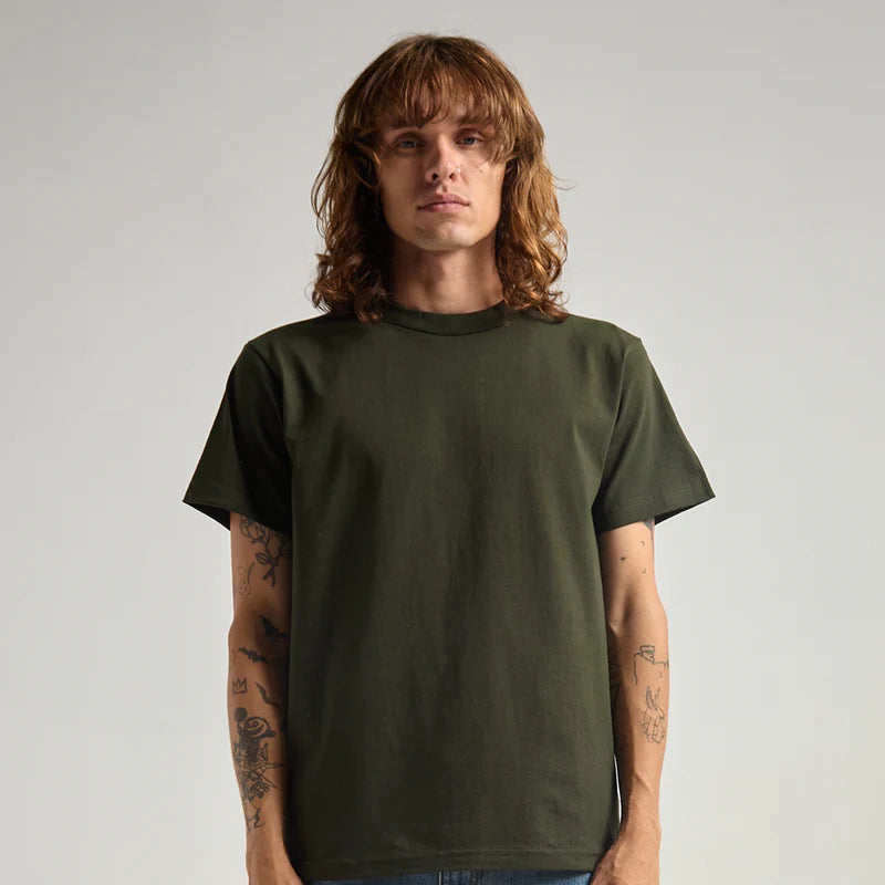Person wearing a green t-shirt and blue jeans against a plain background